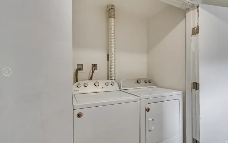 Dedicated laundry area featuring a washer and dryer, utility hookups, and a vent