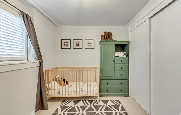 Room featuring light neutral wall paint, a window with horizontal blinds and drapes, and carpeted flooring