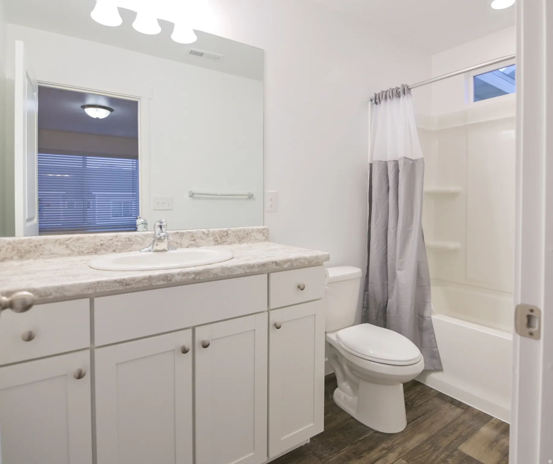 Bathroom featuring a white vanity with a light-toned countertop, a single basin sink, and a chrome faucet