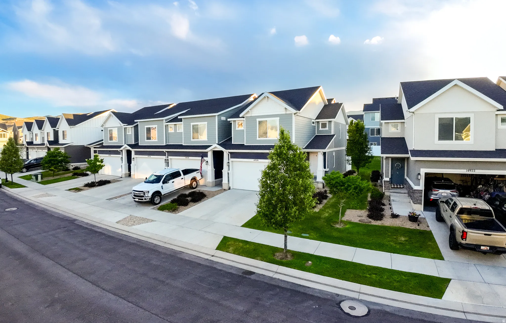 Contemporary townhome-style residences featuring two-story designs with attached garages, asphalt shingle roofs, and light-toned siding