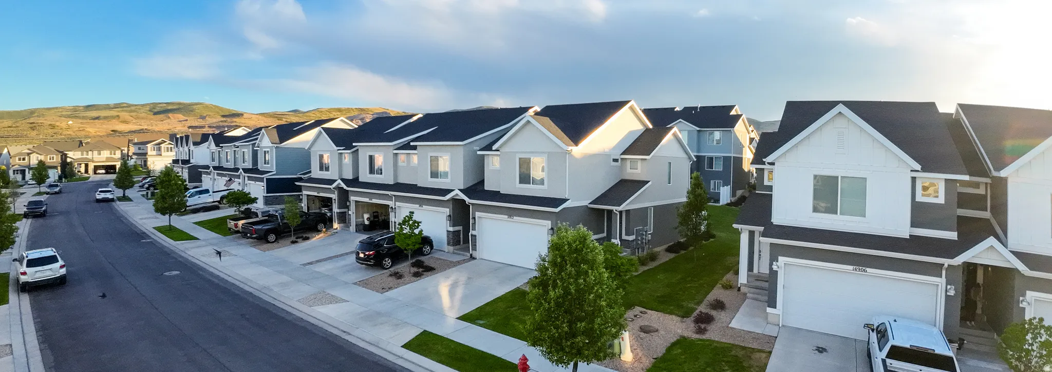 Row of multi-level residences featuring light gray and dark gray siding, white trim, and dark shingle roofs
