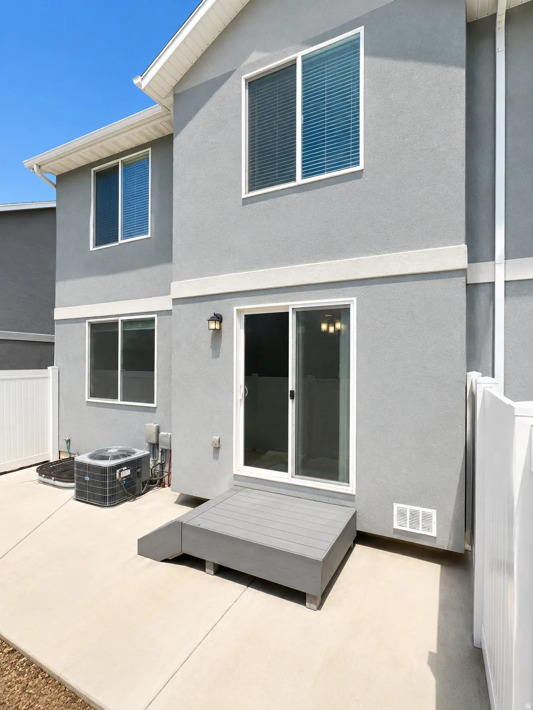 Exterior wall featuring textured gray stucco and white trim