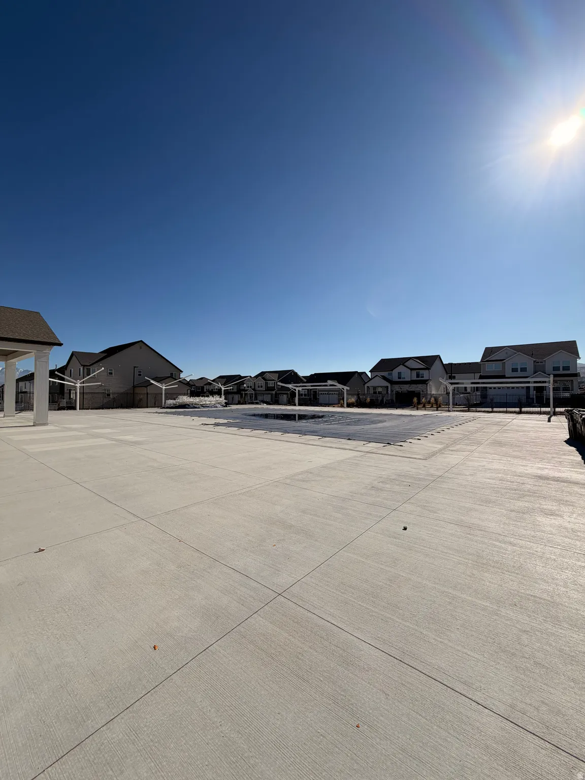Expansive concrete patio surrounding a covered pool area