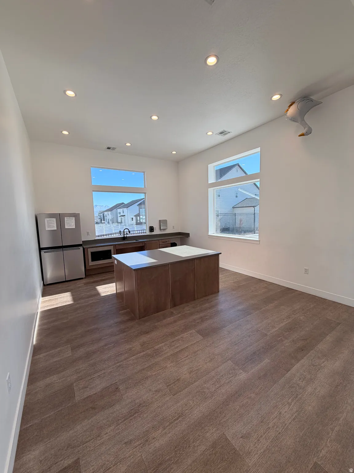 Open-concept space featuring wood-finish flooring, recessed lighting, and large windows providing ample natural light