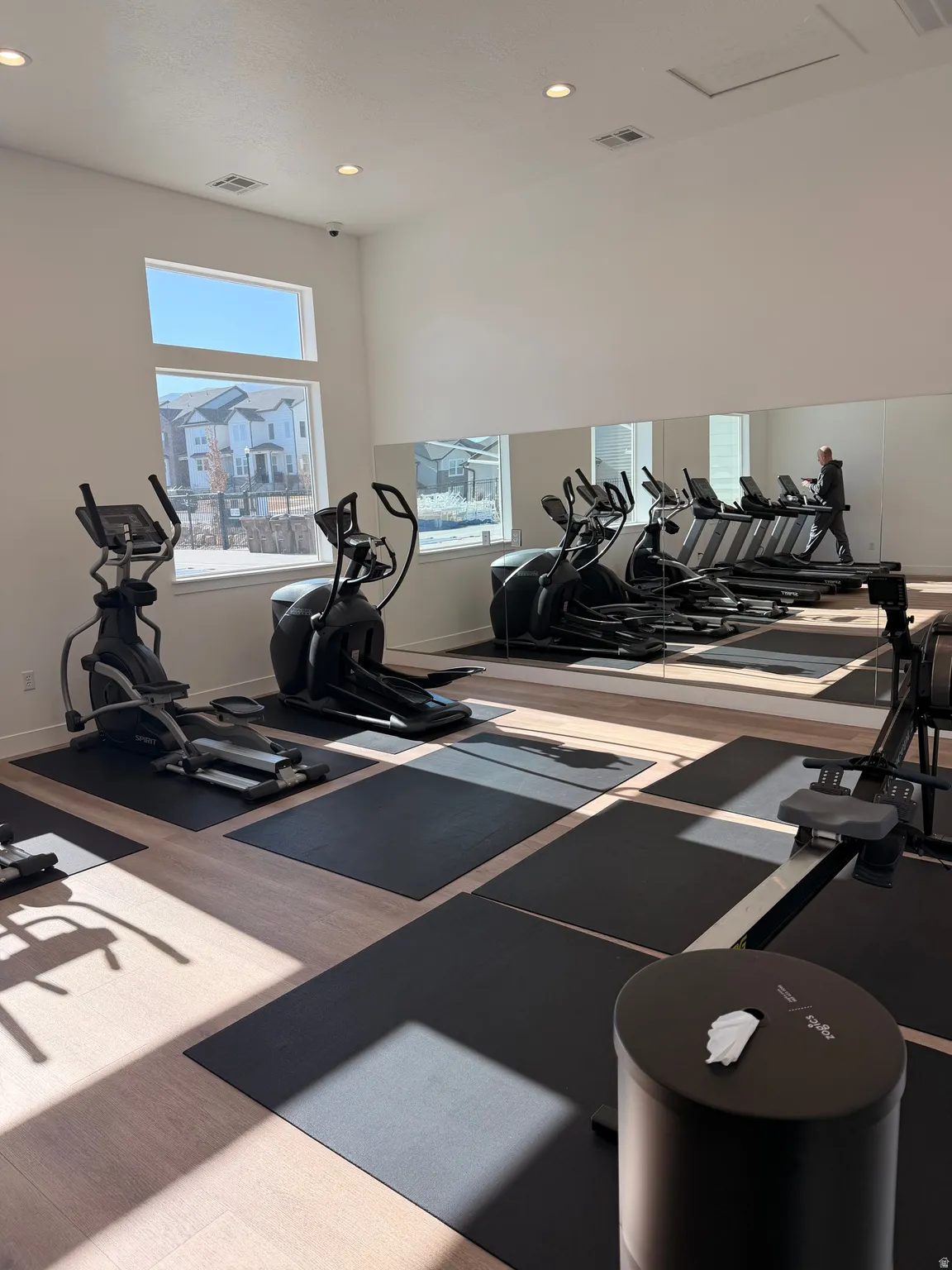 Fitness area featuring light wood-finish flooring and recessed lighting