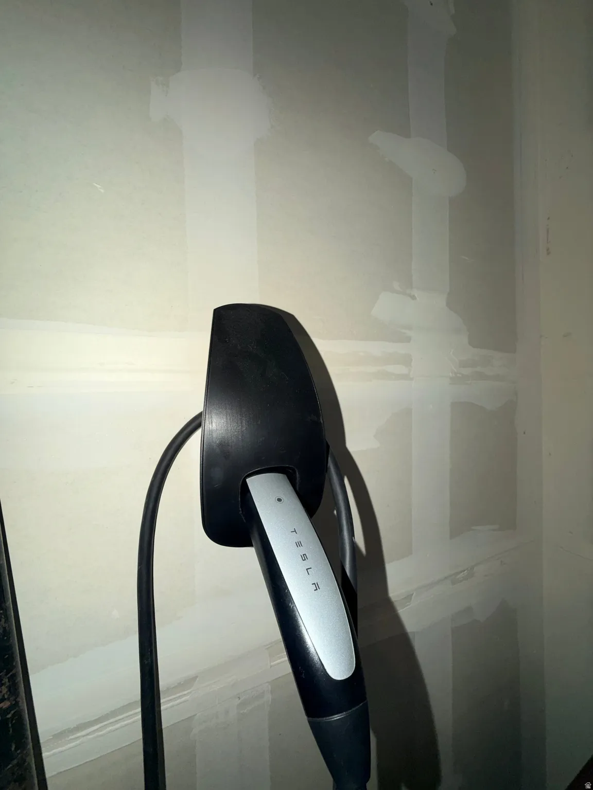 Dedicated Tesla charging station installed on a light-colored wall