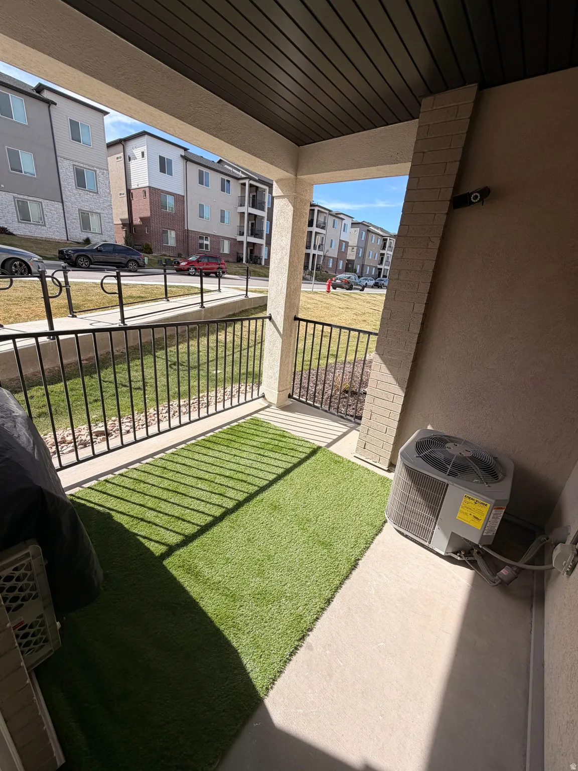 Covered patio featuring concrete flooring and a dark slatted ceiling