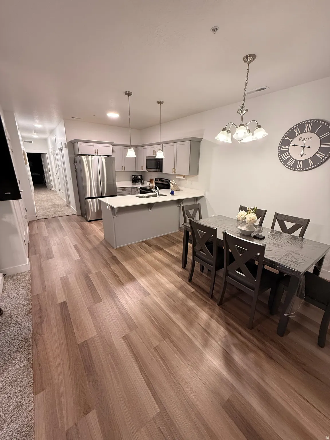 Open-concept kitchen and dining area featuring wood-finish flooring