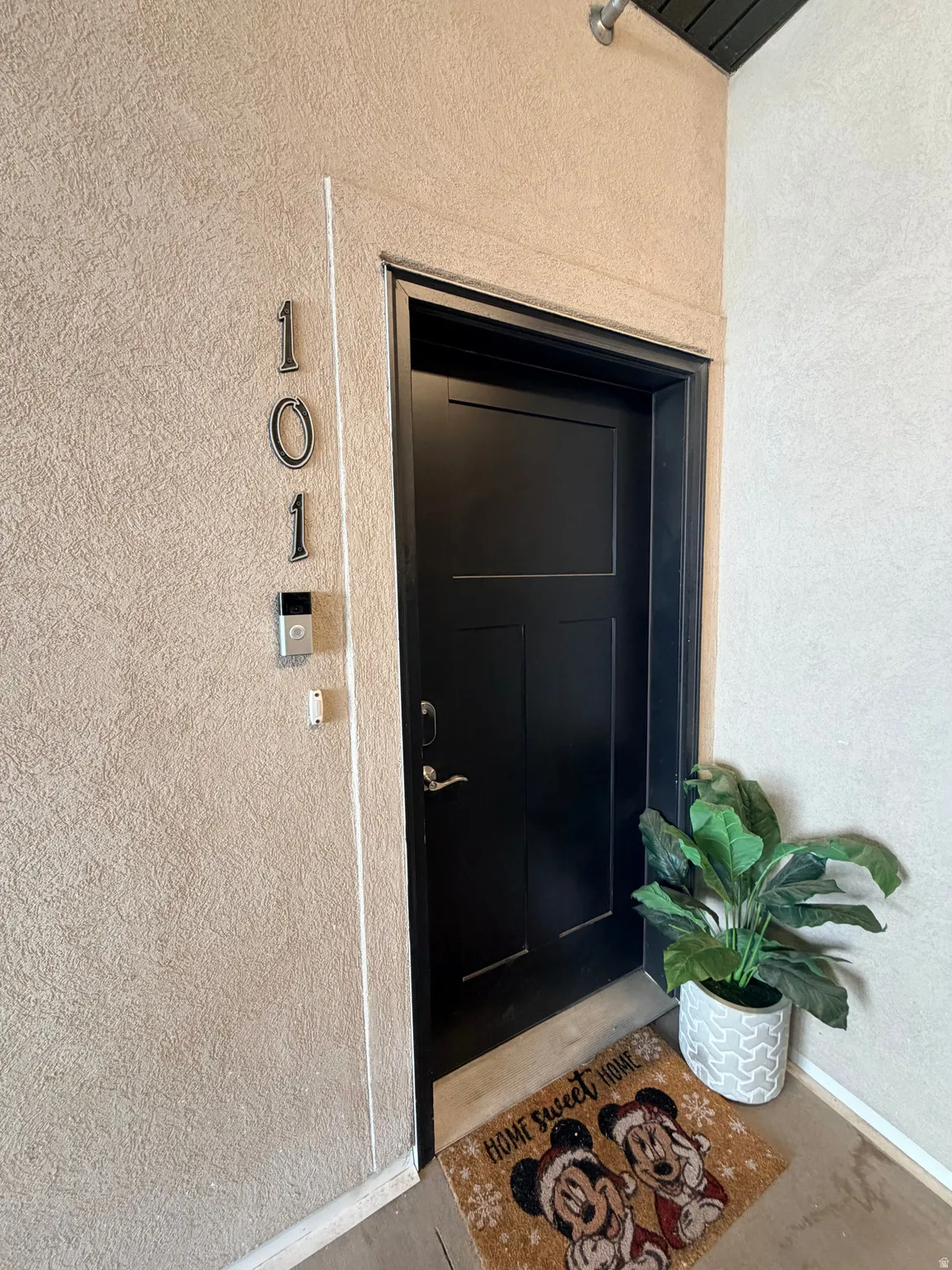 Smooth stucco exterior wall with prominent modern house numbers