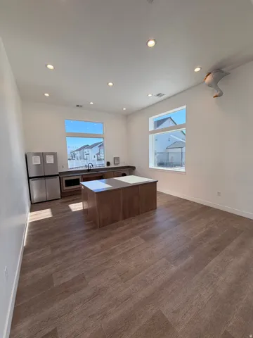 Open-concept space featuring wood-finish flooring, recessed lighting, and large windows providing ample natural light