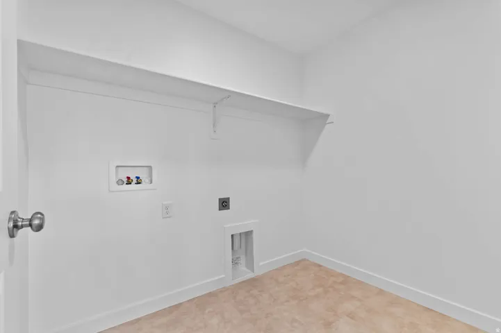 Dedicated laundry area featuring a white wall shelf, appliance hookups, and neutral-toned tile flooring
