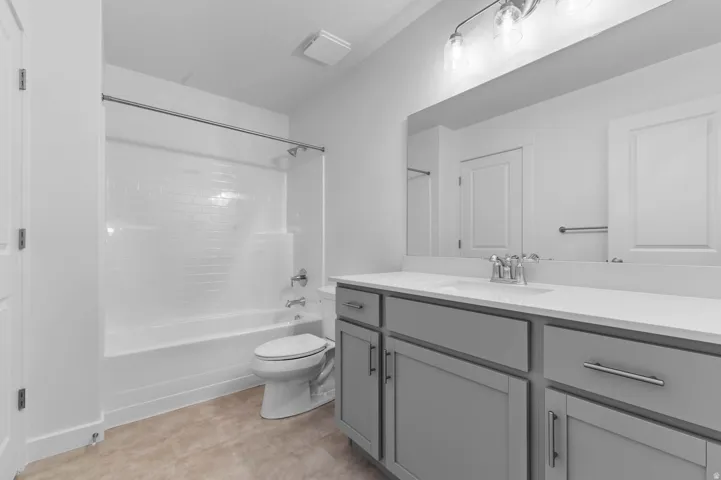 Contemporary bathroom featuring a spacious vanity with gray cabinetry and brushed nickel hardware
