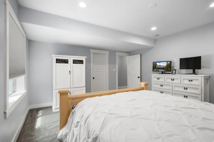 Carpeted room featuring recessed lighting, a window with blinds, and white trim throughout
