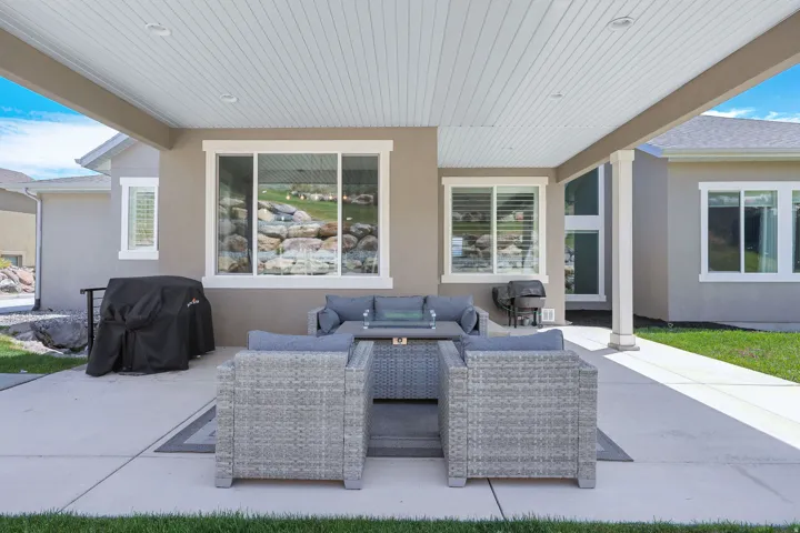Covered patio with a planked ceiling featuring recessed lighting, a concrete slab, and stucco exterior walls