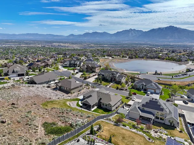 Aerial view showcasing a residential area with a prominent central lake and distant mountain range