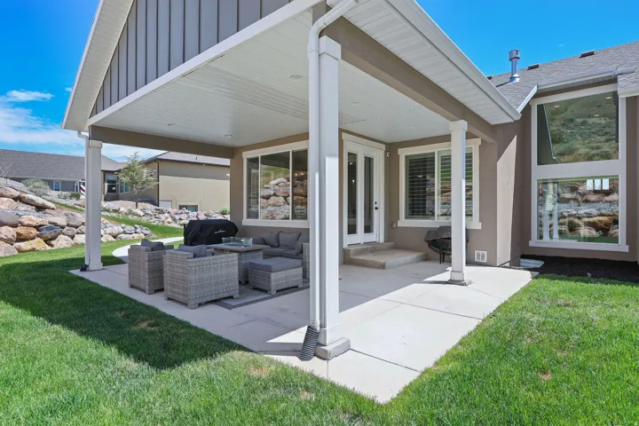 Covered patio featuring a concrete slab and white support columns