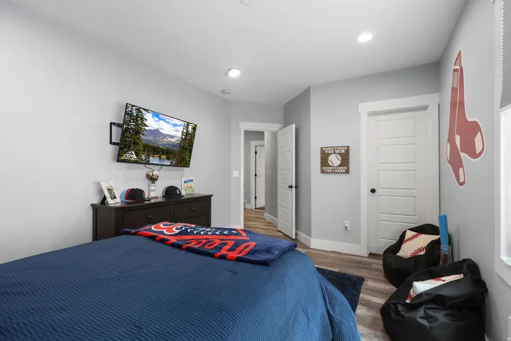 Spacious room featuring light gray walls, white trim, and wood-finish flooring