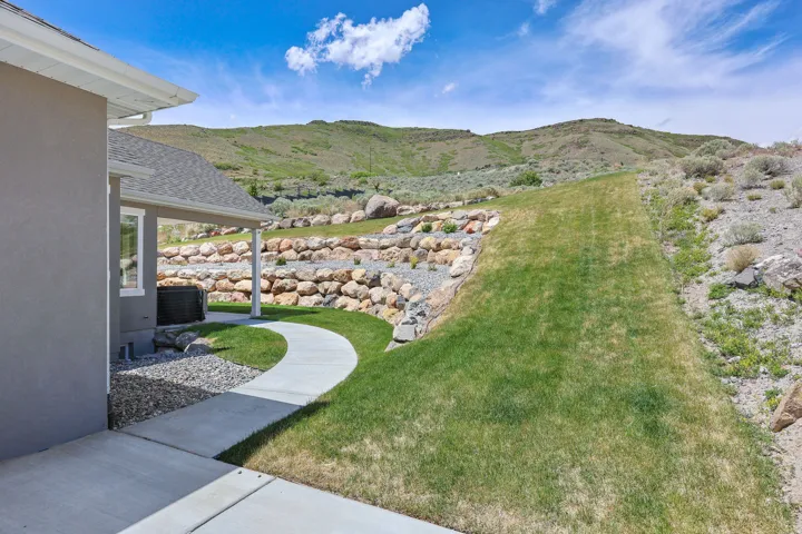 Concrete patio area and curved pathway leading to a covered outdoor space