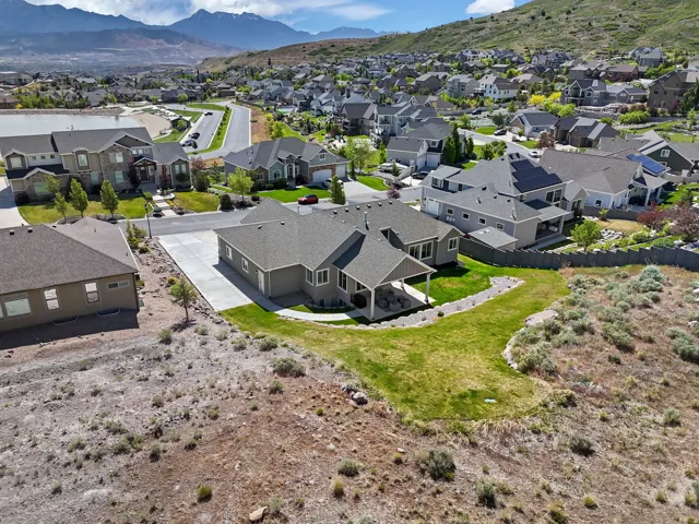 Contemporary residence with a covered patio and a paved driveway, set against a mountainous backdrop