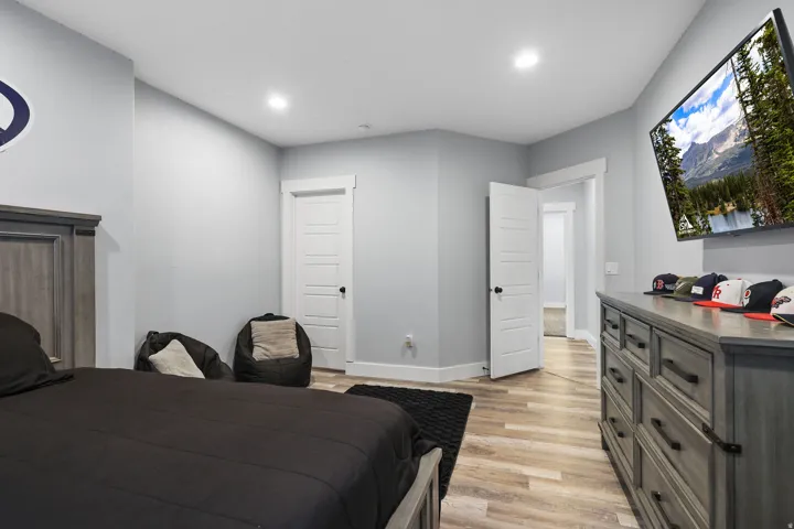 Interior room featuring light gray walls, recessed ceiling lighting, and wood-finish flooring