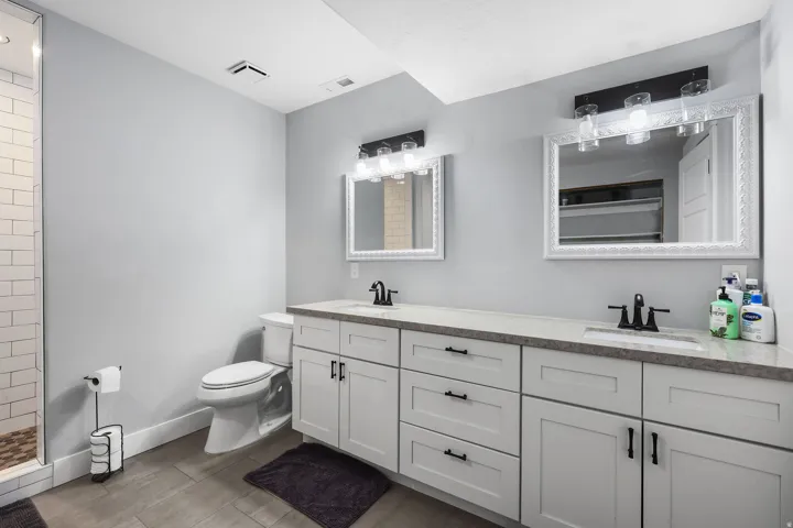 Dual vanity with light-toned countertops and white cabinetry