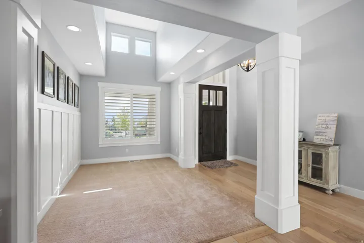 Inviting foyer with a dark wood entry door, light wood-finish flooring, recessed lighting, and a prominent board-and-batten accent wall