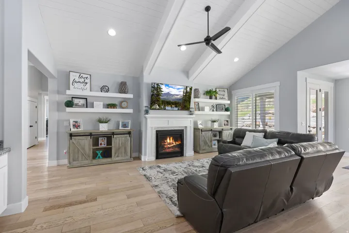 Living area featuring vaulted ceilings with exposed beams and recessed lighting