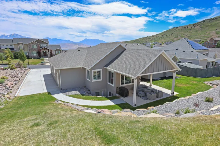Rear exterior featuring a covered patio, stucco siding, and a gabled roofline