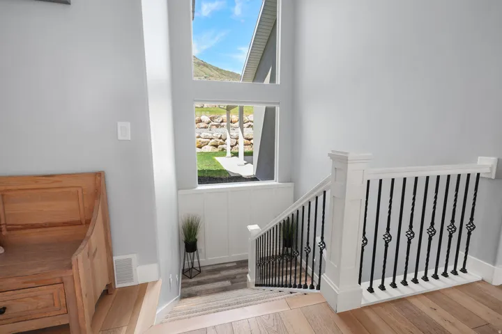 Staircase featuring white newel posts and handrails with black twisted wrought iron balusters