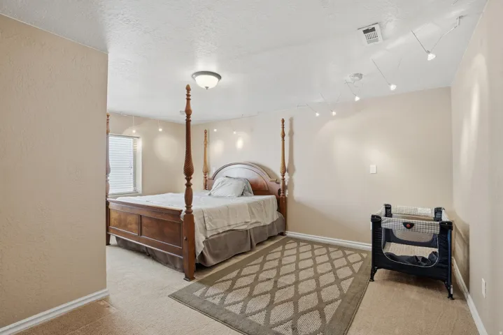 Carpeted room with neutral-toned walls, white trim, and a window with blinds