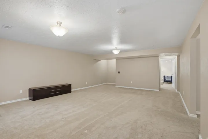 Spacious room featuring neutral carpeting and light-toned walls