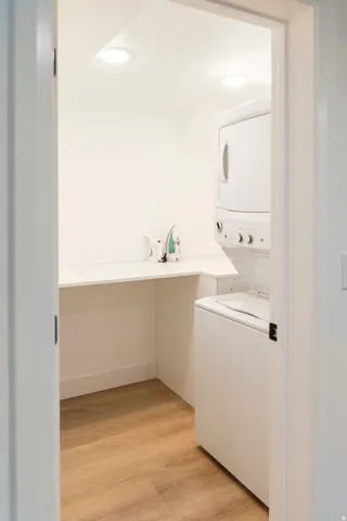 Dedicated laundry area with wood-finish flooring and recessed lighting