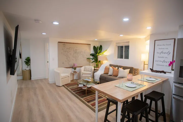 Open-concept living space featuring wood-finish flooring, recessed lighting, and white walls