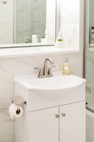 White vanity with integrated basin and brushed nickel faucet
