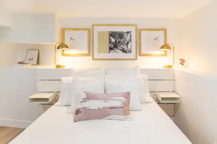 Built-in white headboard with integrated floating nightstands