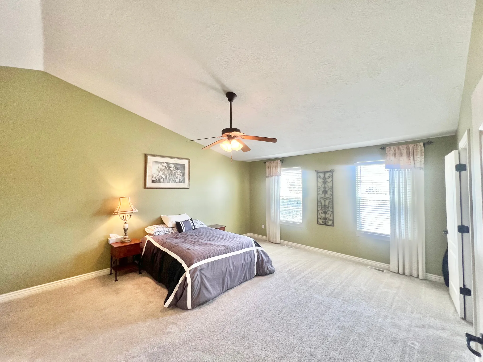 Expansive room with vaulted ceilings and wall-to-wall carpeting