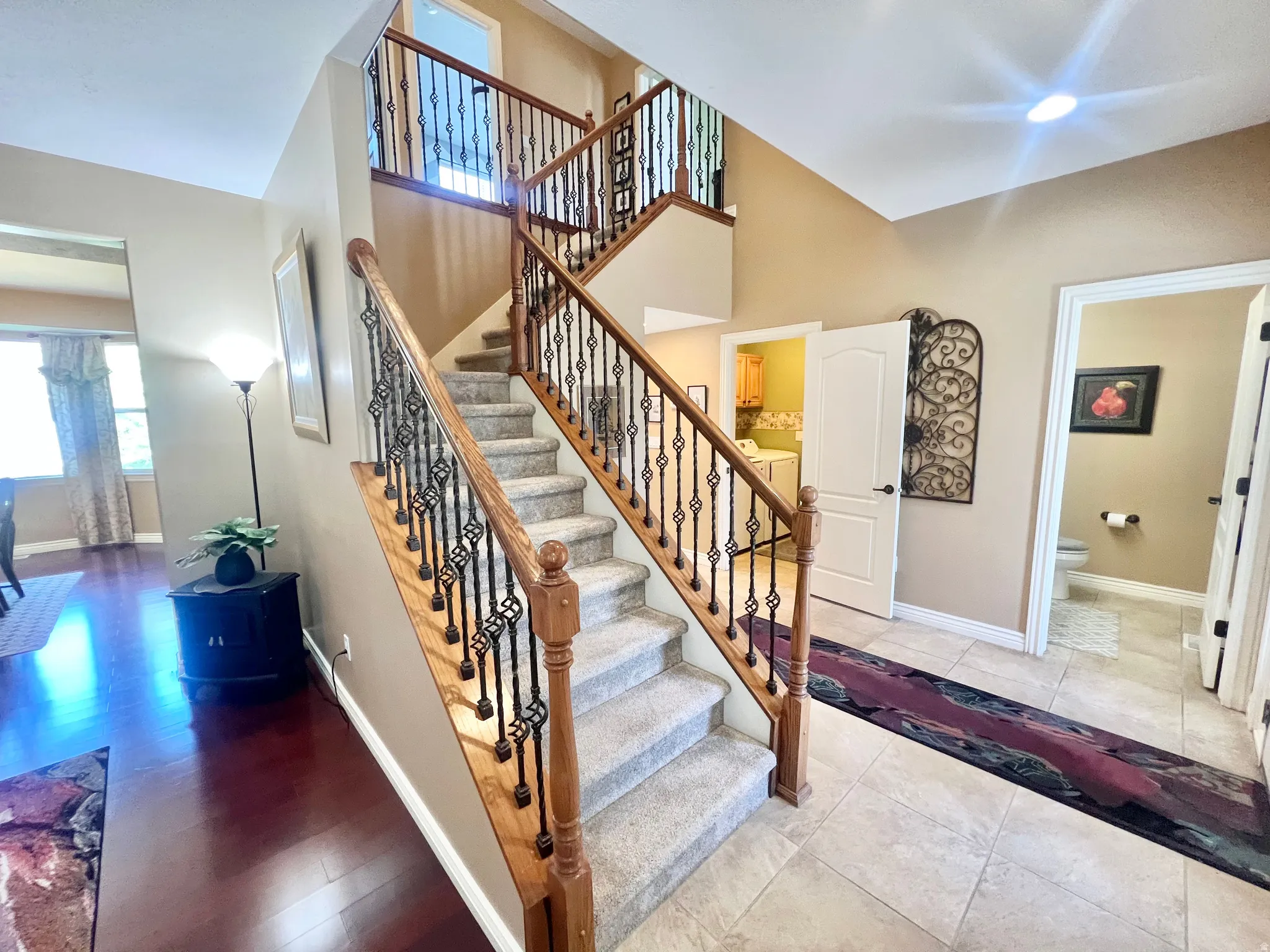 Grand central staircase featuring wood handrails and decorative wrought iron balusters