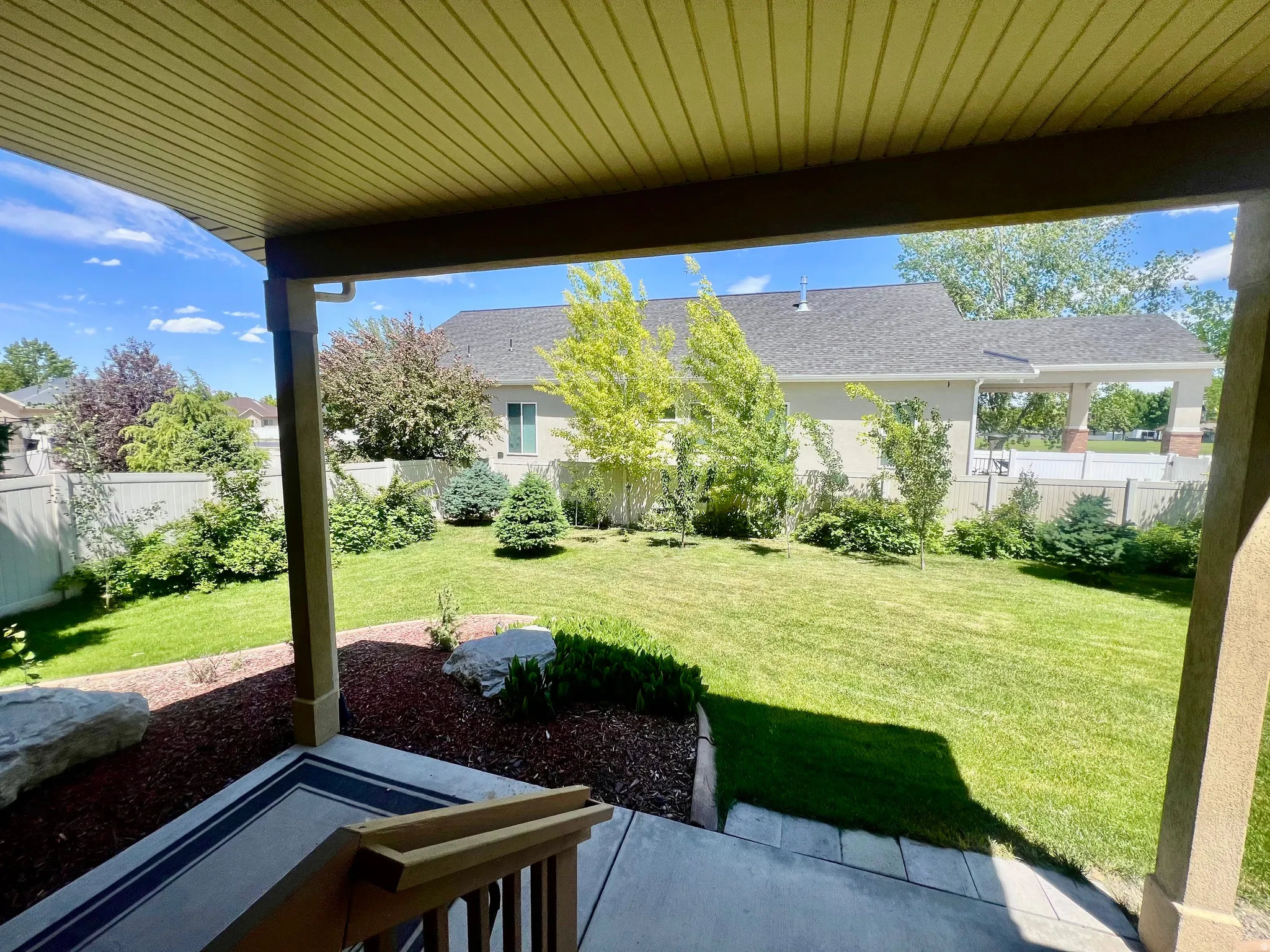 Covered patio with a beadboard ceiling and concrete flooring