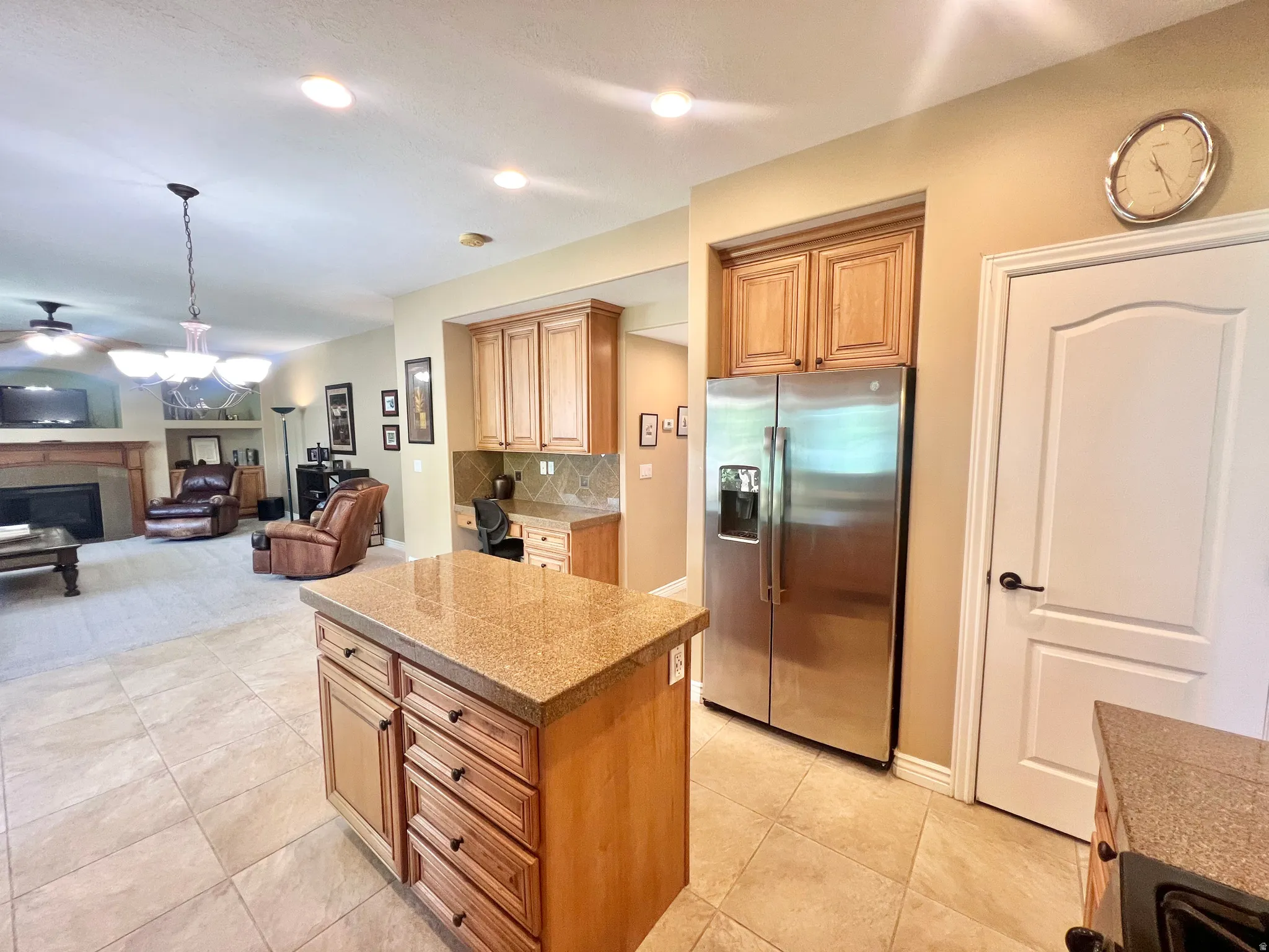 Kitchen island with stone-finish countertop and ample storage cabinetry