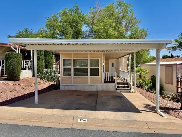 Property exterior featuring a covered carport, porch with railing, exterior siding, and a white entry door