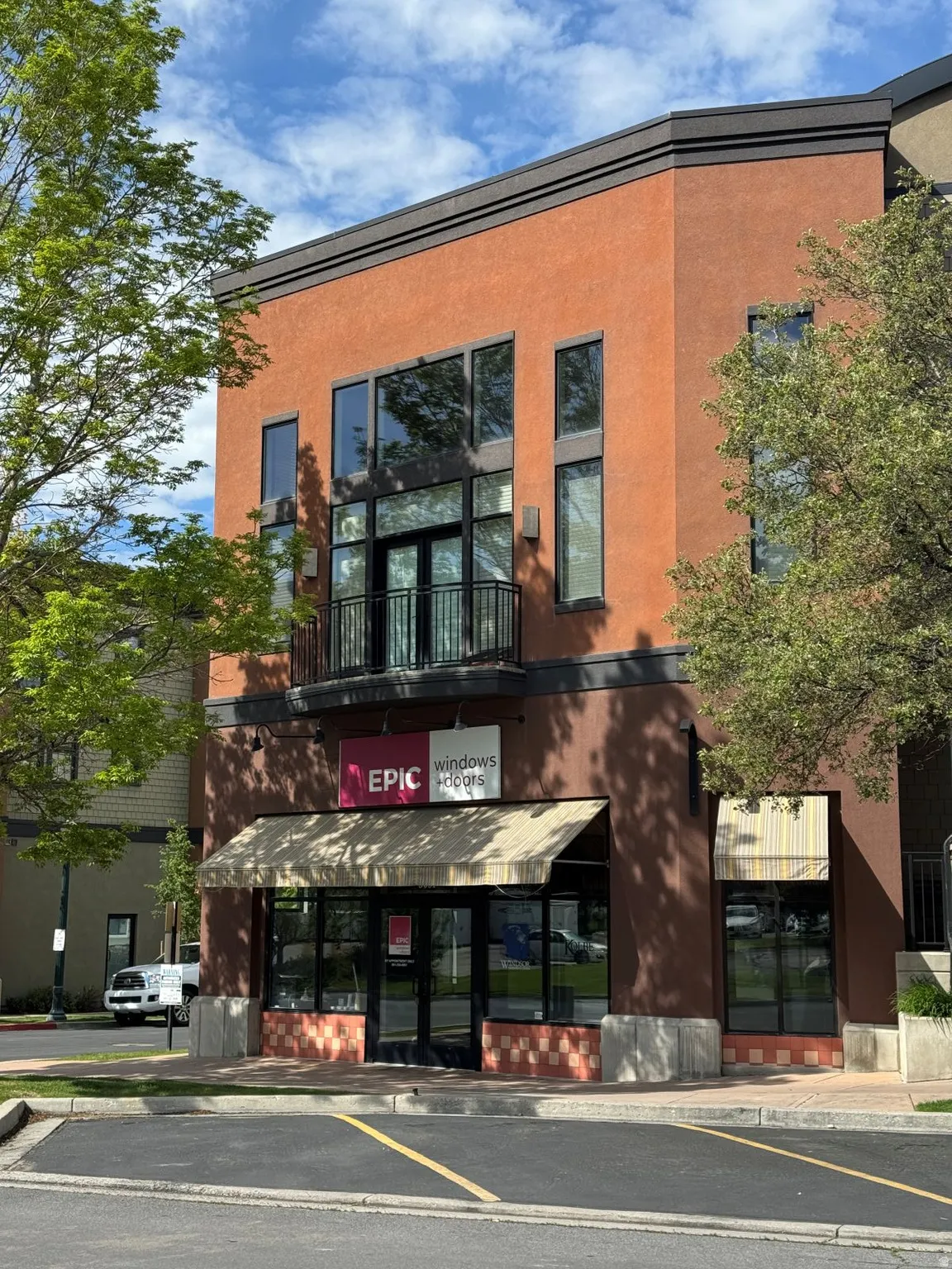 Commercial building featuring a terracotta-colored stucco facade with dark brown trim