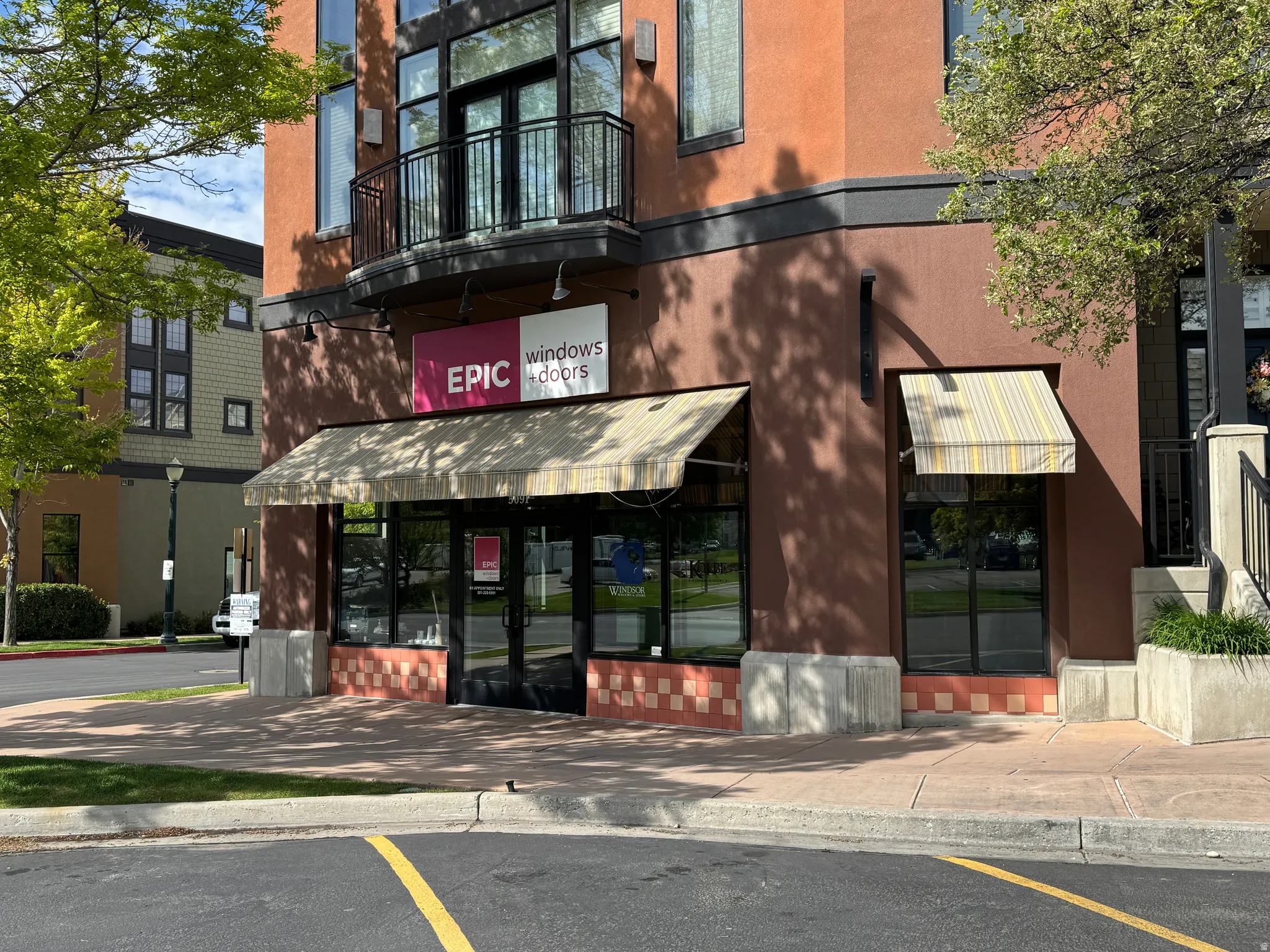 Storefront commercial space featuring a prominent awning, large display windows, and a tiled lower facade