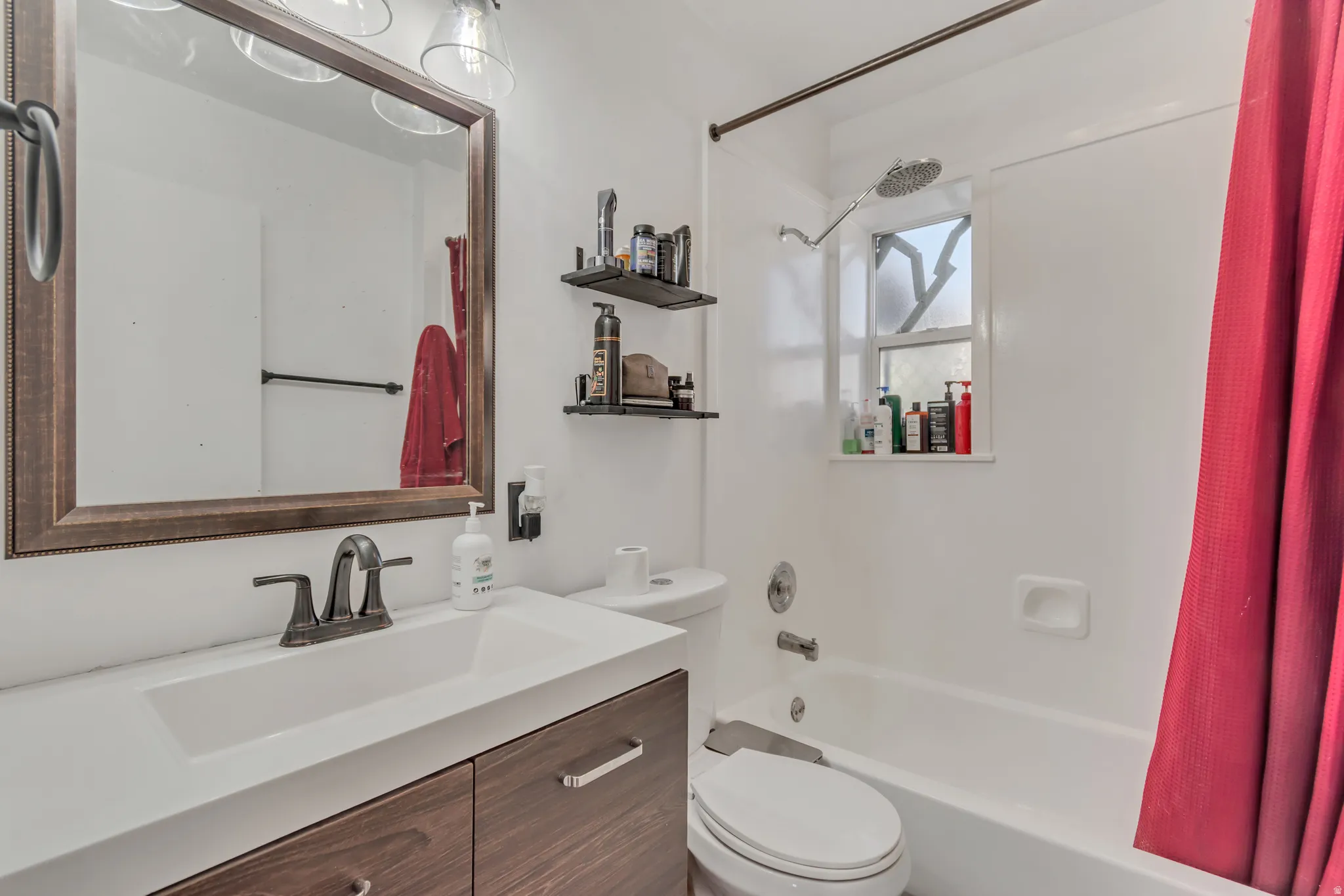 Full bathroom featuring a single vanity with wood-finish cabinetry, a white countertop, and a rectangular undermount sink