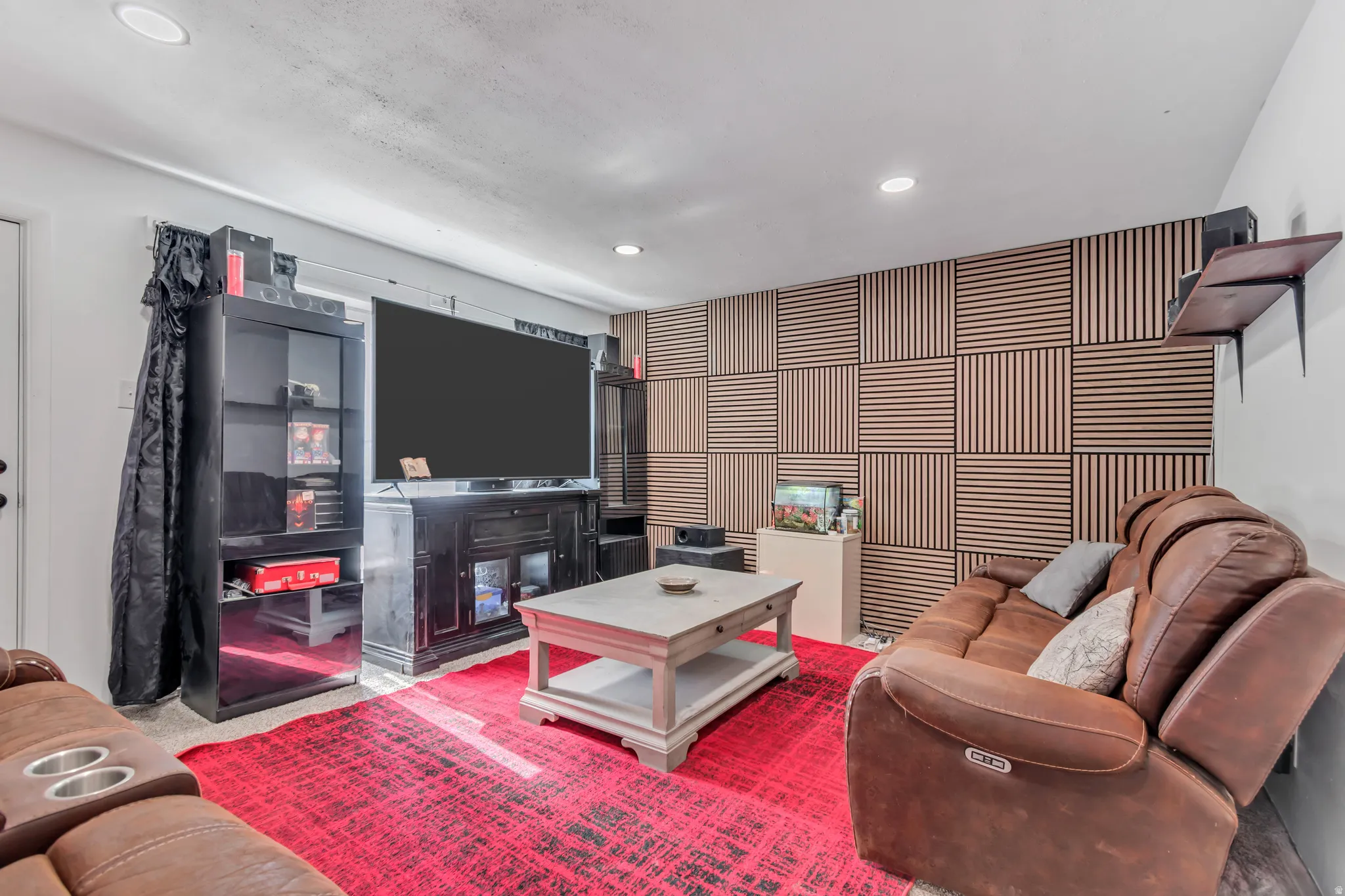 Recreation room featuring a paneled accent wall, recessed lighting, and a white interior door