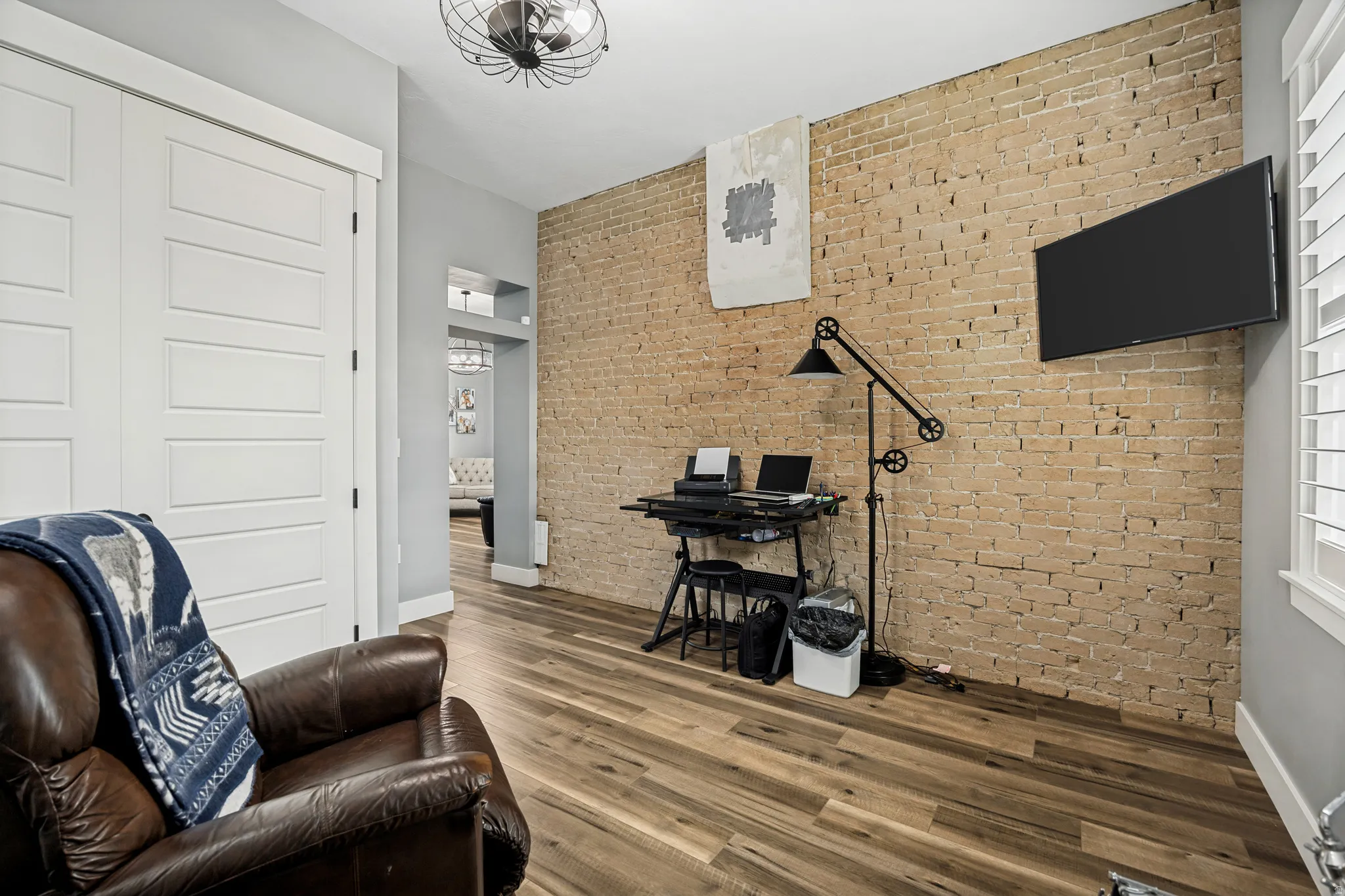 Exposed brick accent wall with wood-finish flooring