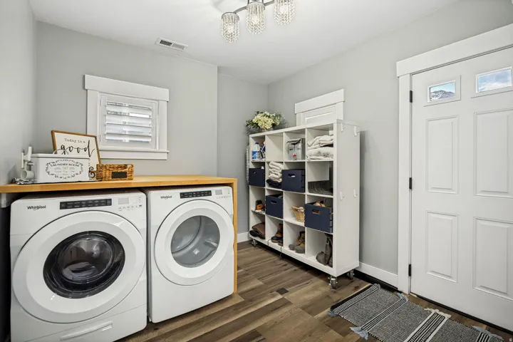 Dedicated laundry area featuring wood-finish flooring and a light wood countertop