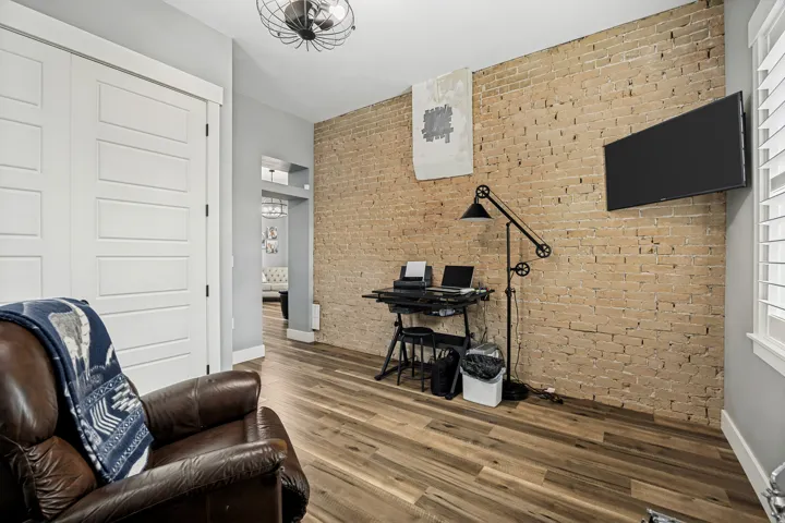 Exposed brick accent wall with wood-finish flooring