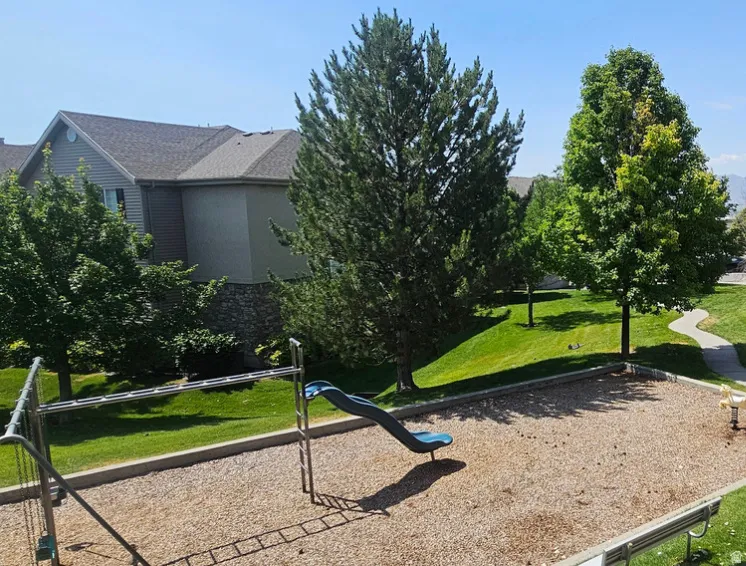 Common area playground featuring a slide, monkey bars, and a spring rider