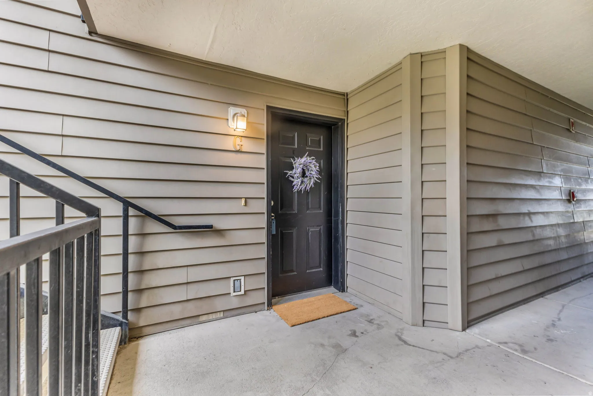 Entryway featuring a paneled door, exterior wall sconce, and horizontal siding