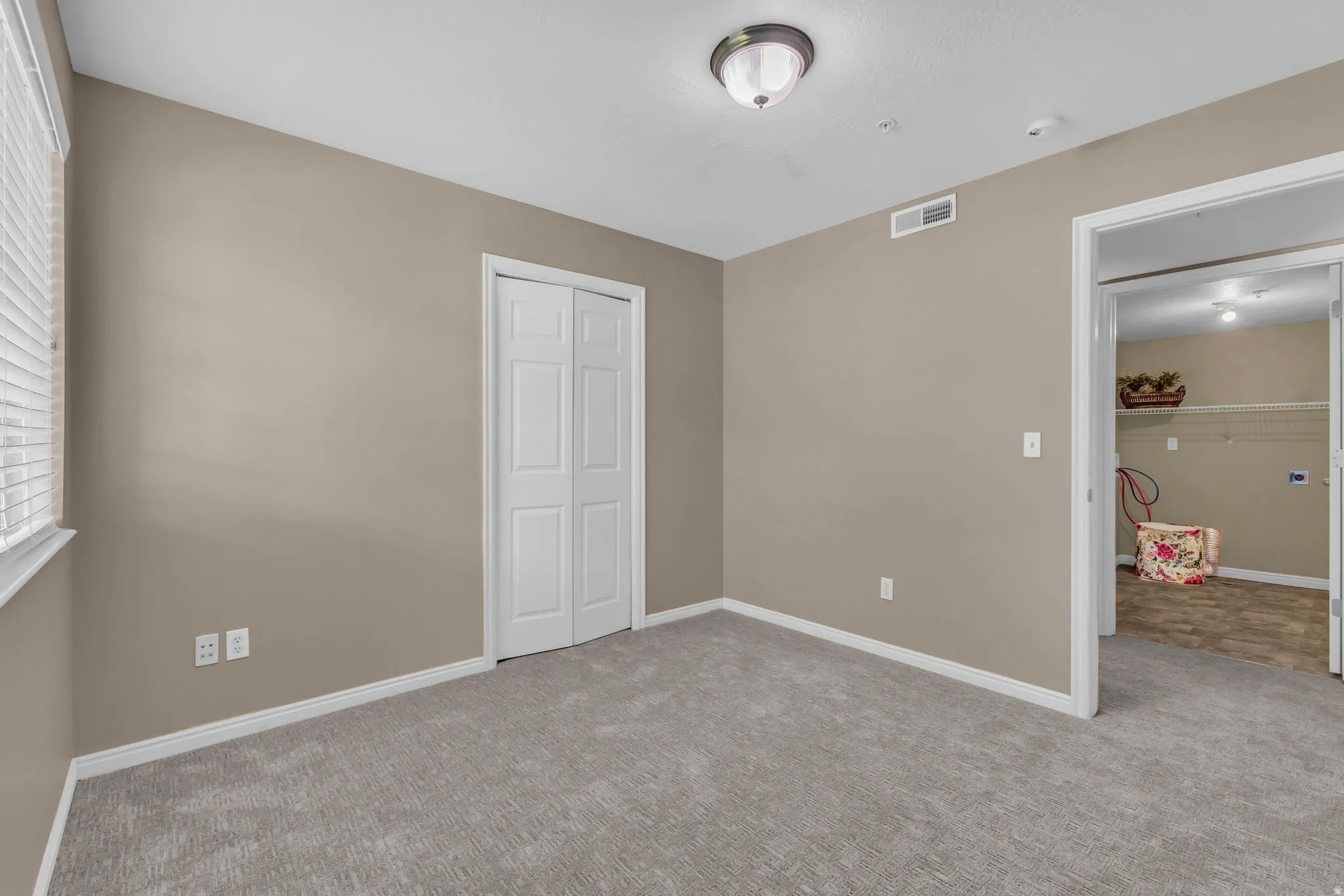 Carpeted room with neutral wall tones and white trim